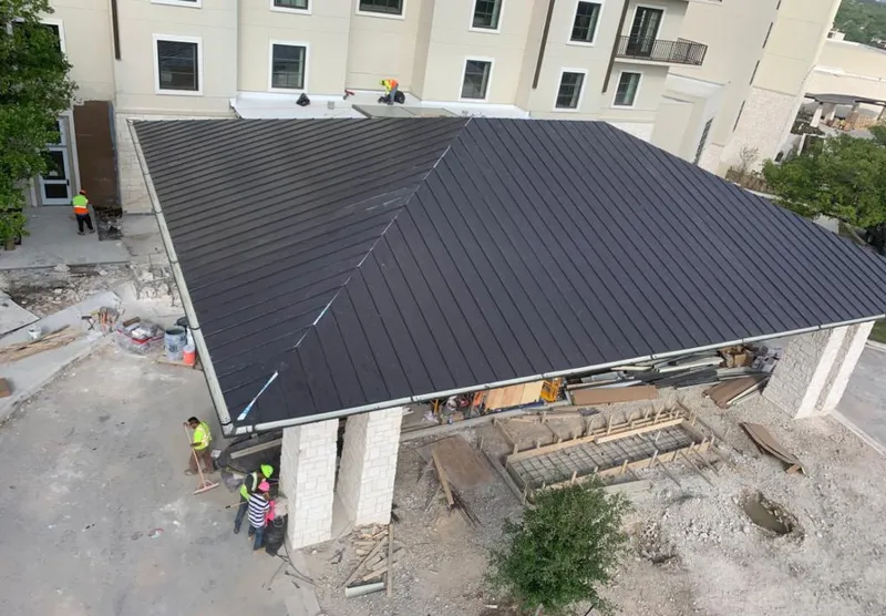 Metal roofing installation team working on a commercial building in Whitehall